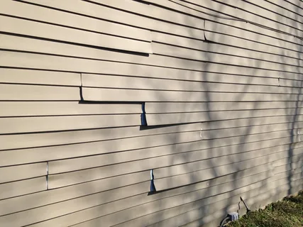 Damaged vinyl siding needing surface repair before painting — professional preparation by ProCut Paint for paint vinyl siding projects